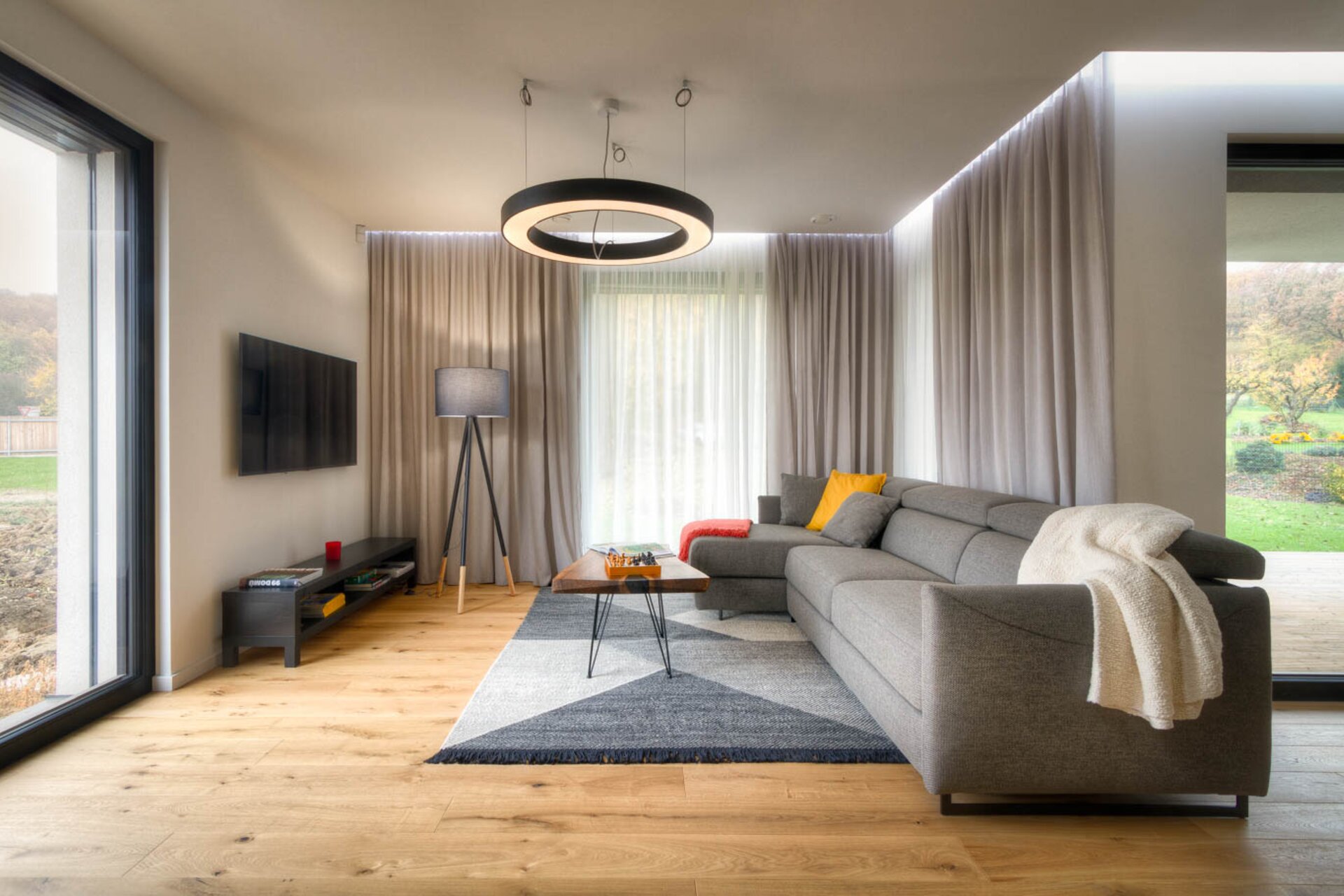 Moderní kuchyně v pasivním domě ZEO Moonglade I – minimalistický design, přírodní dřevěná podlaha, vestavěné spotřebiče a velká prosklená okna s výhledem do zahrady. Moderní kuchyně v pasivním domě ZEO Moonglade I – minimalistický design, přírodní dřevěná podlaha, vestavěné spotřebiče a velká prosklená okna s výhledem do zahrady.