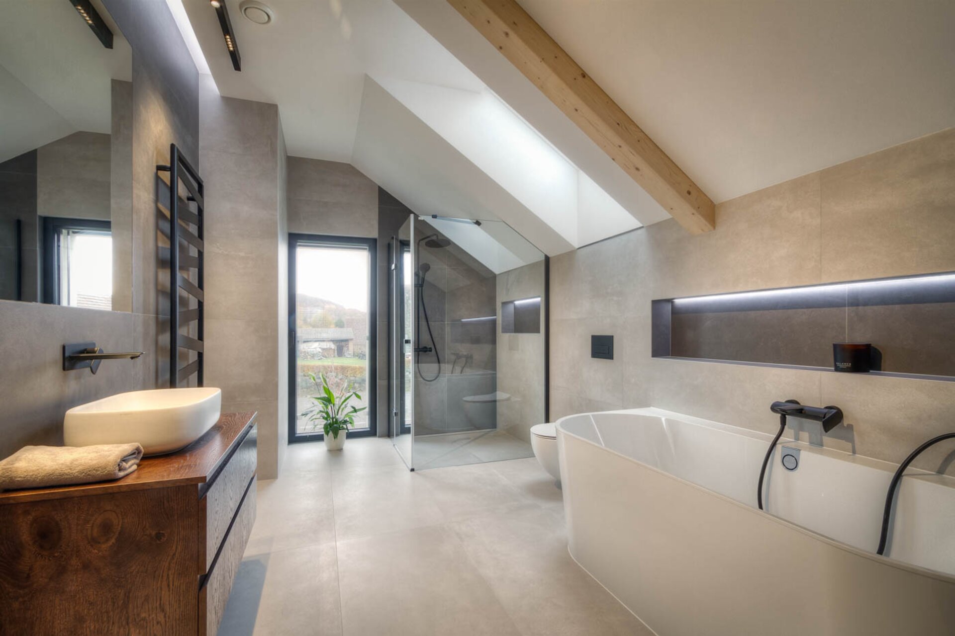 Designová koupelna v pasivním domě ZEO Moonglade I s volně stojící vanou, walk-in sprchovým koutem a střešním světlíkem. Designová koupelna v pasivním domě ZEO Moonglade I s volně stojící vanou, walk-in sprchovým koutem a střešním světlíkem.
